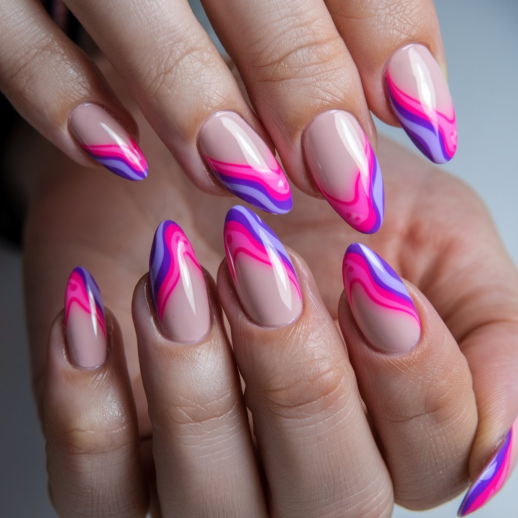 A photo of a woman's hand with five fingers adorned with neon pink and purple swirl nails. The vibrant, wavy patterns contrast against a sheer nude base, creating an eye-catching, modern design. A glossy finish enhances the fluidity of the lines as they reflect the natural background lighting. The nails are shaped into a trendy almond style, and the skin appears fresh and hydrated, further emphasizing the striking color combination. Each nail features the same design.