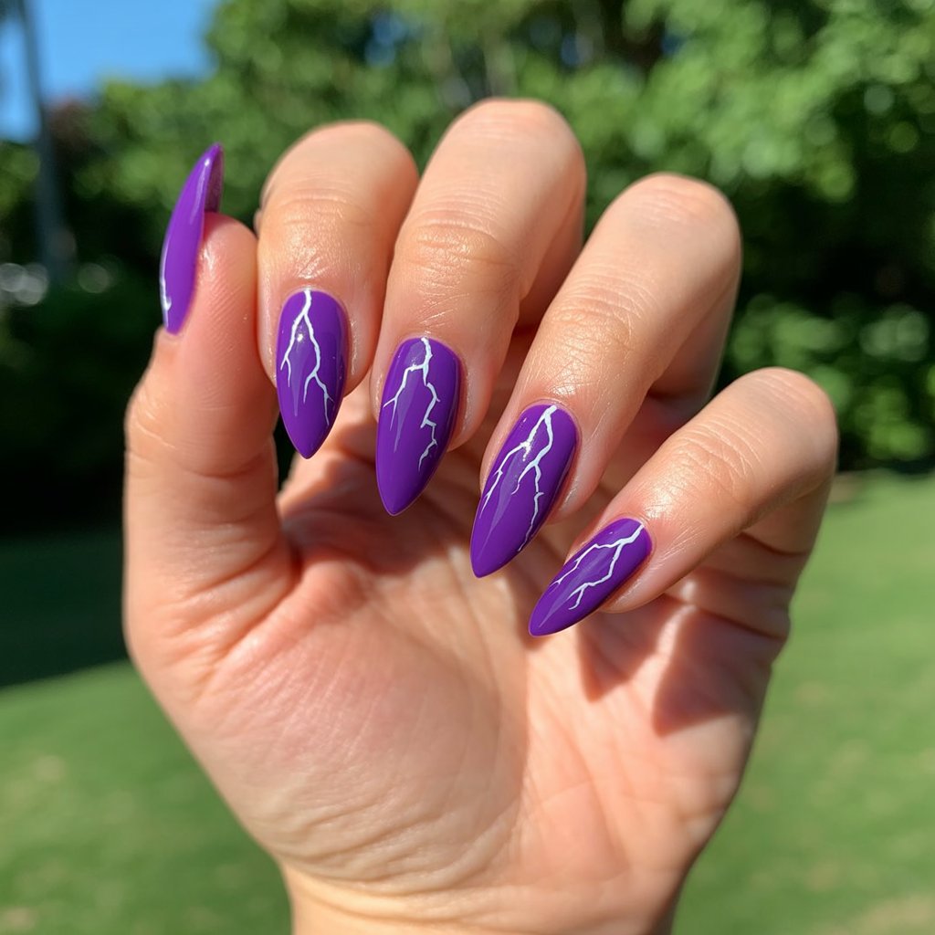 A photograph showcasing a close-up of a woman's hand, the primary focus resting on her meticulously manicured nails. Each of the five fingers displays a striking stiletto shape, adorned with a deep neon purple polish featuring delicate hand-painted white lightning bolts, creating a dynamic and electric design. Natural sunlight gently illuminates the hand against a softly blurred outdoor background of lush greenery, causing the purple polish to glow intensely and the lightning bolts to shimmer subtly. The skin appears well-moisturized and dewy, complementing the vibrant manicure and healthy cuticles, further highlighting the striking contrast.