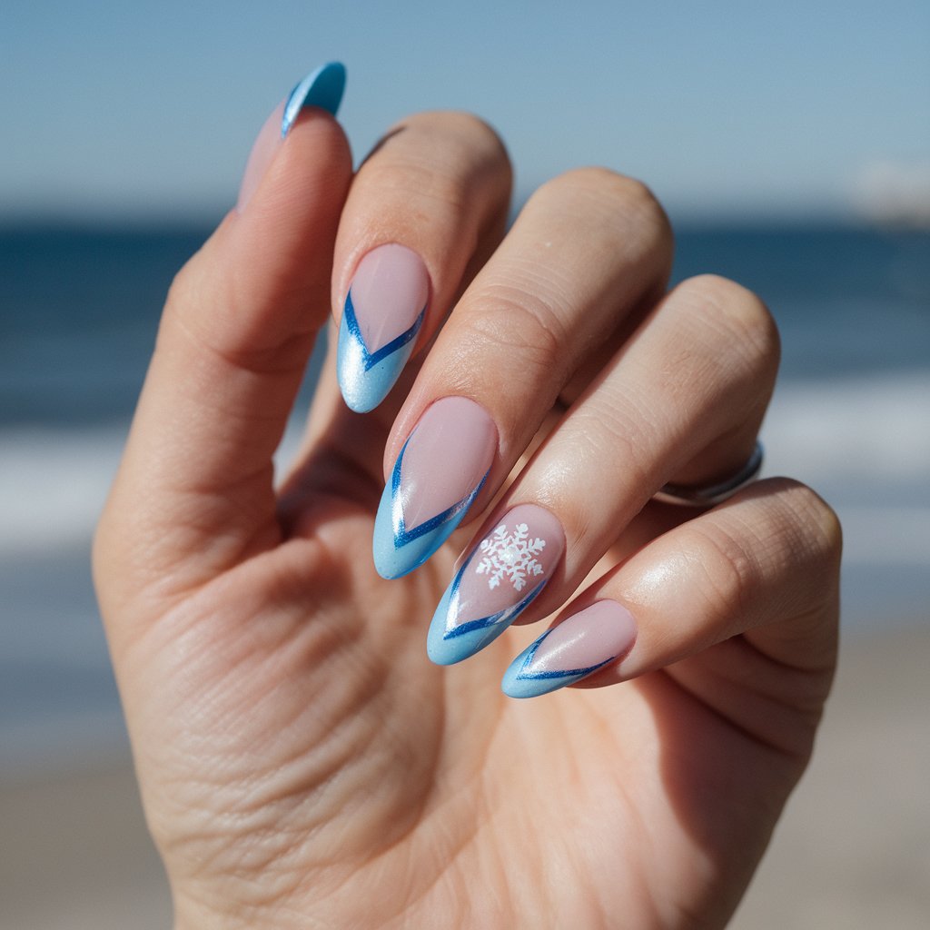 A photo of a woman's hand with frosty ice blue cat eye nails. The nails are almond-shaped and painted in a pale blue with silver undertones. A sharp magnetic line shimmers like frozen light, and a tiny white snowflake decal graces the ring finger. The hand is shown in a relaxed pose, fingers gently splayed. The background is a blurry image of a bright sunny day at the beach with the ocean in the distance.